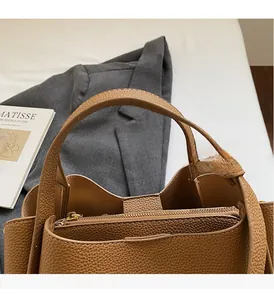 Dettaglio borsa a mano color caramello in pelle litchi con tasca interna a cerniera