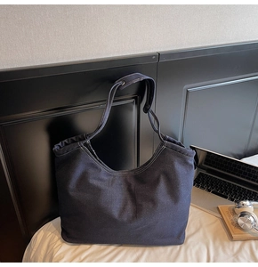 Détail du grand sac cabas en denim bleu foncé avec surpiqûres blanches contrastées