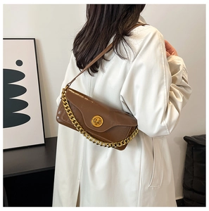 Detail of dark brown vintage shoulder bag with gold chain and circular swivel lock