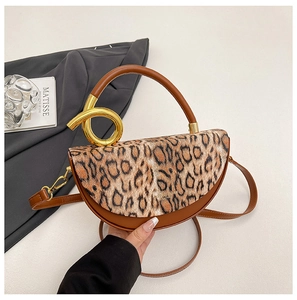 Detail of artistic gold metal twist lock and leopard print flap on the leather bag