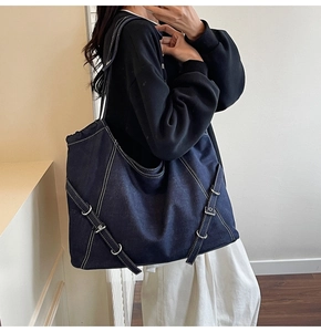 Détail du sac cabas en jean bleu foncé avec surpiqûres contrastées blanches et boucle
