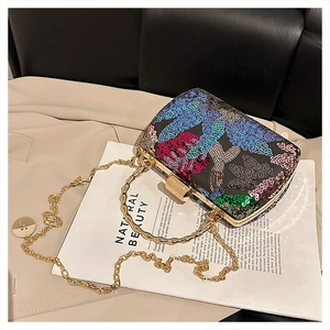Macro detail of floral sequin embroidery and golden metal frame on shell clutch bag