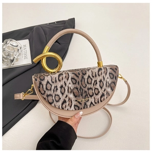 Detail of leopard print handbag featuring a unique gold twisted knot metal handle handle
