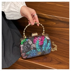 Detail of colorful sequins and golden bamboo-shaped handle on a formal evening shell bag
