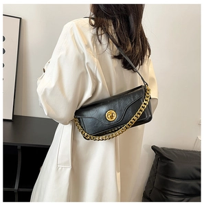 Detail view of black faux leather bag with stone texture and chunky gold chain strap