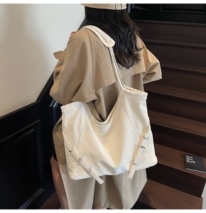 Détail du grand sac cabas crème avec sangles à boucles argentées et texture cuir souple