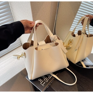 Dettaglio borsa in pelle bianca con tasca centrale a zip e finiture in metallo dorato