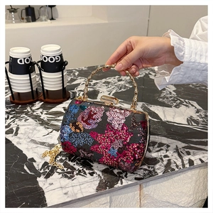 Detail of floral sequin evening bag with gold bamboo handle and chain strap
