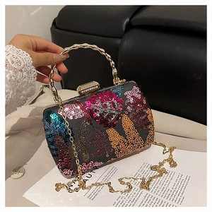 Detailed shot of sequin embroidery floral clutch with golden bamboo handle and chain