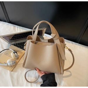 Dettaglio della borsa tote in pelle beige con manico a nodo e custodia interna