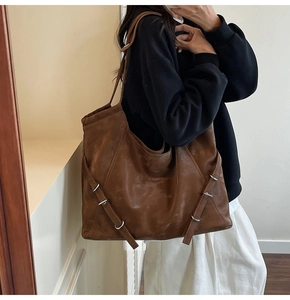 Vue détaillée du sac cabas en cuir mat marron avec sangles et boucles métalliques