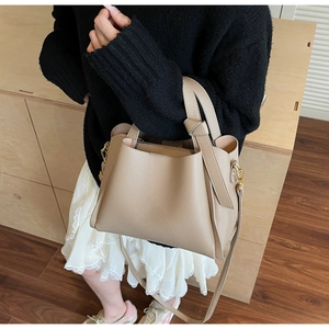 Dettaglio borsa a mano beige in pelle martellata con manico a nodo e oro hardware
