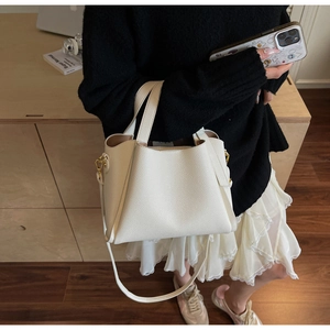 Dettaglio della borsa in pelle bianca con trama litchi e hardware in metallo dorato