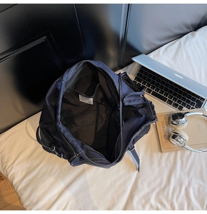 Détail du sac en jean montrant l'intérieur spacieux et les surpiqûres blanches