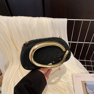 Sparkly black rhinestone evening clutch bag with a large golden oval handle and chain