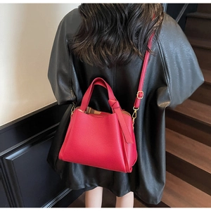 Dettaglio borsa in pelle martellata rossa con hardware dorato e tracolla fine
