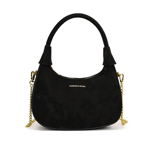 Elegant black velvet crescent bag with gold chain strap and top handle on white background
