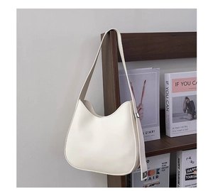 Detail of white moon hobo bag hanging on dark wood with silver buckle and smooth PU leather