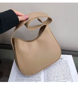 Detail of minimalist khaki crescent shoulder bag with thick strap and matte leather texture