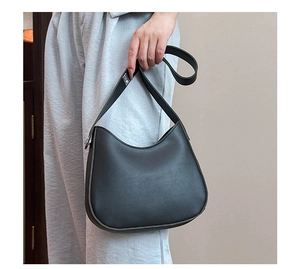 Detail of black matte leather hobo bag featuring adjustable silver buckle and fine grain texture