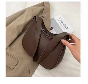 Detail of dark brown hobo shoulder bag with smooth texture and silver zipper on neutral background