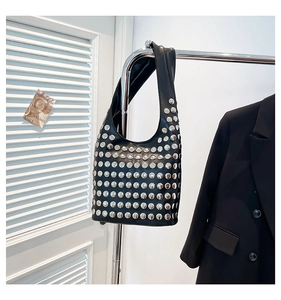 Détail du sac hobo noir avec rivets argentés sur un sac à bandoulière au style rétro