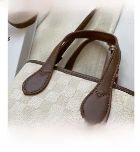 Detailed macro view of checkered texture with premium brown leather handles and stitching