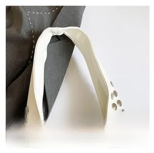 Détail du sac à bandoulière en cuir blanc avec rivets argentés et anse large