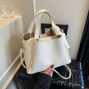 Borsa a mano minimalista beige in pelle martellata con manico annodato e dettagli dorati