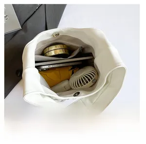 Intérieur spacieux du sac à rivets blanc montrant la capacité pour téléphone et cosmétiques