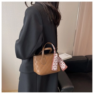 Brown checkered handbag with silk scarf detail worn by model in black blazer