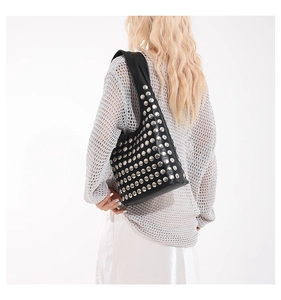 Détails des rivets argentés sur sac à épaule punk noir porté par un mannequin