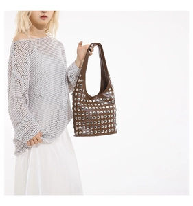 Gros plan d'un sac bandoulière marron en similicuir avec clous argentés style hobo