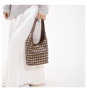 Sac hobo marron clouté porté par un mannequin pour un look bohème chic et moderne