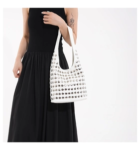 Détail du sac à bandoulière en cuir blanc avec des rivets métalliques argentés décoratifs