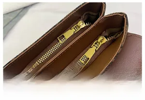 Close-up of vintage brown leather bag featuring dual golden zippers and star pattern
