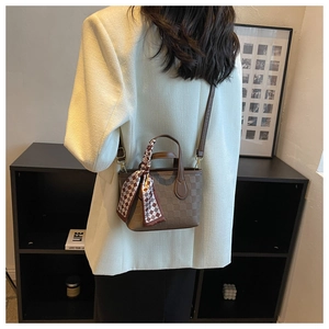 Detailed back view of vintage plaid square bag with decorative silk scarf on shoulder