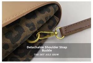 Detail of detachable gold metal buckle on beige leather bag with leopard print lining