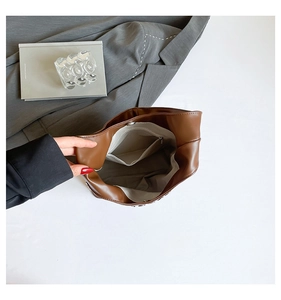 Vue intérieure du cabas en cuir marron montrant la doublure en tissu beige et la poche