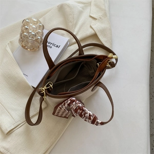 Detail shot of handbag interior featuring zipper compartment and silk scarf decor