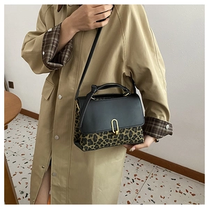 Detail of leopard print crossbody bag featuring gold U-shaped lock and leather flap
