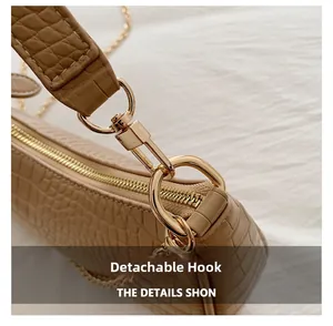 Detail view of the detachable golden metal hook and crocodile texture on the bag