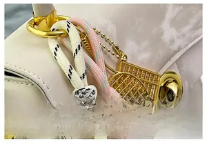 Détails de pendentifs abaque et raquette avec cordons tressés sur un sac à main