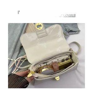 Intérieur d'un sac à bandoulière crème montrant le rangement du maquillage