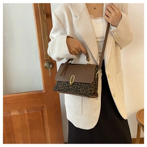 Retro satchel bag with leopard print patchwork and gold buckle worn by model