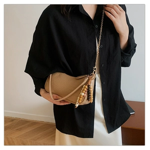 Detail of khaki crocodile pattern baguette bag with wooden bead and metal chain
