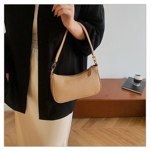 Detail of light khaki crocodile texture underarm bag with gold metal hardware buckle