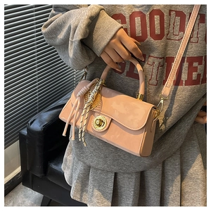 Détail sac à main rose verni avec fermoir rotatif doré et pendentif foulard rayé