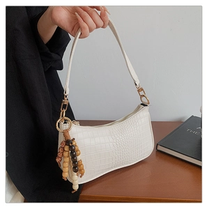 White faux leather baguette bag featuring crocodile pattern and wooden bead charm