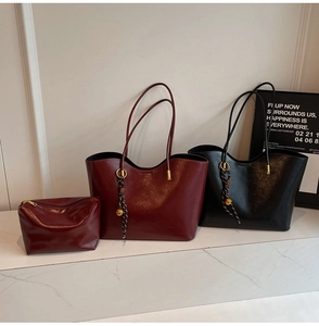 Detail of high-gloss faux leather tote bags with woven rope and golden metal sphere charm
